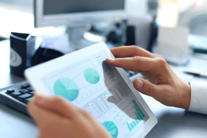 &copy;&nbsp;Business person analyzing financial statistics displayed on the tablet screen